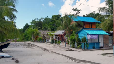 Scenic-view-of-local-street-with-shop-and-guesthouse-on-tropical-island-in-popular-diving-destination-of-Raja-Ampat,-West-Papua,-Indonesia
