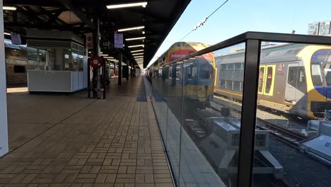 Handheld-Clip,-Der-Am-Bahnsteig-Am-Hauptbahnhof-Sydney-Entlang-In-Richtung-Intercity-Regionalzüge-Läuft