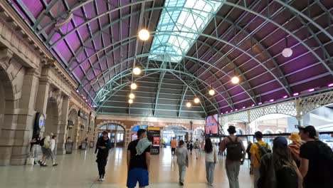 People-walking-through-busy-main-concourse-of-Central-Station-Sydney-with-ceiling-illuminated