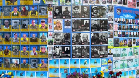 Big-memorial-wall-of-fallen-soldiers-in-Kyiv-Ukraine,-wall-of-honor-for-the-soldiers-who-died-during-the-Russia-Ukraine-war-battle,-honoring-and-remembering-flowers,-4K-shot