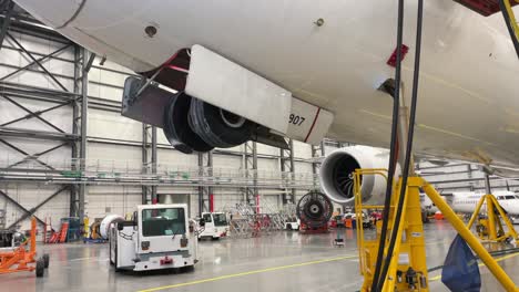 Ein-Boeing-787-Dreamliner-Steht-Zur-Wartung-Auf-Stützböcken,-Um-Das-Fahrwerk-In-Einem-Flugzeughangar-Zu-Schwenken