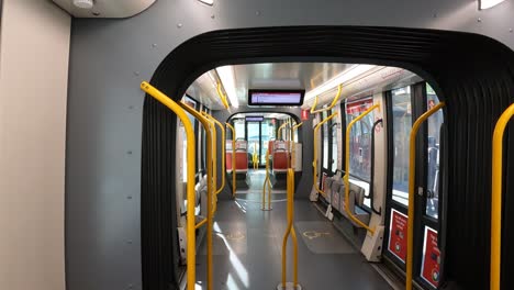 View-onboard-an-empty-Sydney-light-rail-tram,-looking-along-the-carraiges