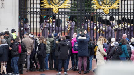 Tourists-Taking-Pictures-with-Phones-at-Gate-Buckingham-Palace-Whilst-Kings-Guard-Band-Plays-Songs,-Changing-of-the-Guard-Ceremony