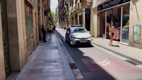 Police-Car-Passing-By-People-In-Street-|-Barcelona-Spain-Immersive-City-Walk-Through-Crowded-Streets-in-Gothic-Quarter,-Europe,-4K