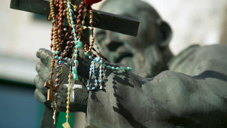 Statue-Des-Heiligen-Pio-Mit-Rosenkränzen-Drapiert-über-Dem-Christlichen-Kreuz,-Das-Er-In-Atrani-An-Der-Italienischen-Amalfiküste-Hält