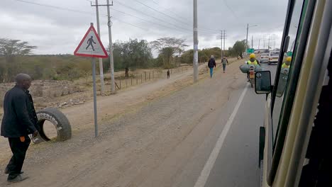 Un-Motociclista-Con-Una-Carga-Pesada-Adelanta-A-Un-Automóvil-Que-Circula-Por-La-Autopista-En-Narok,-Kenia