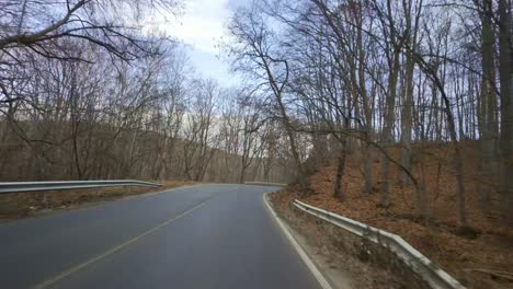 driving-on-the-winding-sub-Balkan-road-E871,-fallen-leaves-on-the-side-of-the-road,-and-another-car-passes-from-the-opposite-side-of-the-road