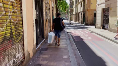 Hombre-Con-Bolsa-De-Supermercado-Caminando-En-El-Callejón-|-Barcelona,-España,-Ciudad-Inmersiva,-Paseo-Por-Calles-Concurridas-En-El-Barrio-Gótico,-Europa,-4k