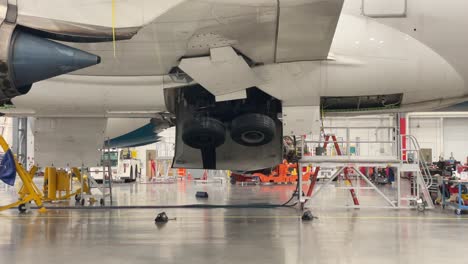 Bei-Einem-Boeing-787-Flugzeug-Ist-Das-Fahrwerk-Eingefahren,-Während-Das-Flugzeug-Auf-Stützböcken-In-Einem-Hangar-Steht