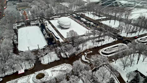 Aerial-view-toward-the-Bean,-snowy-Cloud-Gate,-cloudy,-winter-day-in-Chicago,-USA