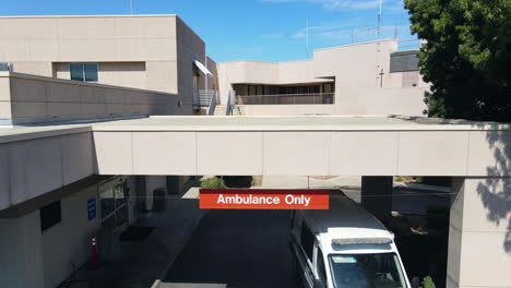 Aerial-view-away-from-a-paramedics-ambulance-at-a-hospital-in-sunny-Los-Angeles,-USA