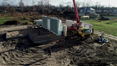 A-crane-unloads-the-panels-for-the-construction-of-a-prefabricated-house