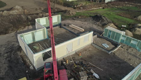 Aerial-view-of-the-site-of-a-prefabricated-house,-where-windows-and-panels-stand-waiting