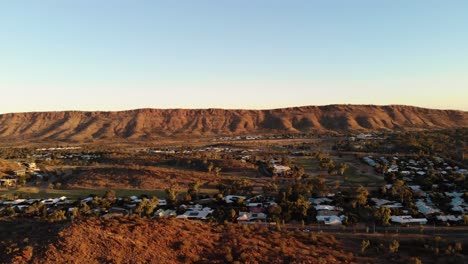 Left-Trucking-Drone-Shot-of-the-mountains-and-town-in-Alice-Springs,-Australia