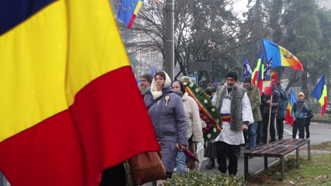 Romanian-citizen-carrying-flags,-objects-in-National-Day-Parade,-Miercurea-Ciuc