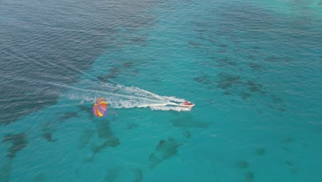 Luftaufnahme-Von-Touristen-Beim-Parasailing-über-Dem-Türkisfarbenen-Wasser-Der-Karibik