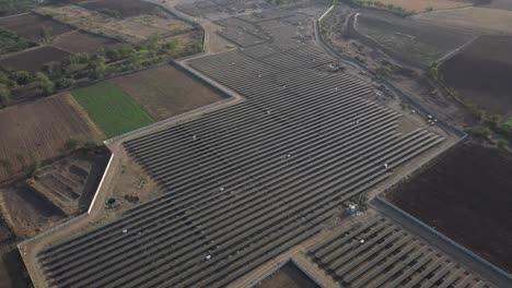 Aerial-drone-view-is-behind-where-a-large-solar-power-plant-and-a-large-power-station-are-visible