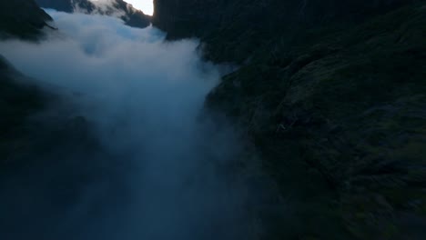 FPV-Drohne-Fliegt-In-Den-Bergen-Durch-Nebel-Und-Wolken-Bei-Sonnenuntergang