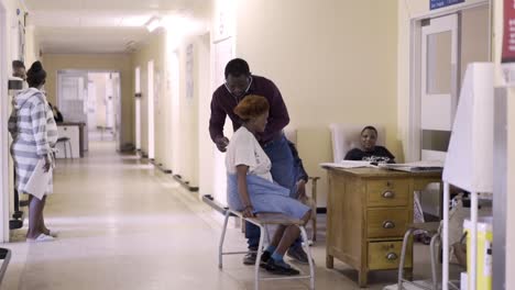 Wide-shot,-African-Doctor-gives-elderly-woman-check-up-at-hospital