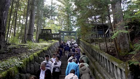 tourists-ascend-the-staircase-leading-to-Okusha-Hoto-in-Nikko,-Japan,-to-explore-the-structure-that-houses-the-remains-of-Tokugawa-Ieyasu