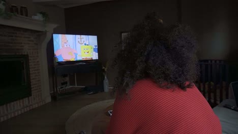 Woman-watching-cartoons-on-the-television-in-her-living-room