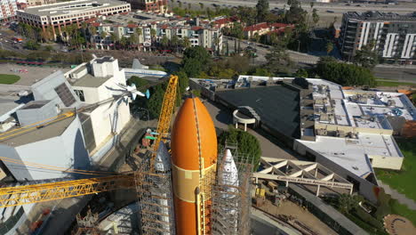 Drone-flying-backwards-over-a-space-rocket,-at-a-the-California-ScienCenter-in-LA