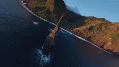 Drone-Fpv-Volando-Sobre-El-Océano-Azul-Entre-Formaciones-Rocosas-En-La-Costa-De-Ribeira-Da-Janela,-Madeira-Al-Amanecer