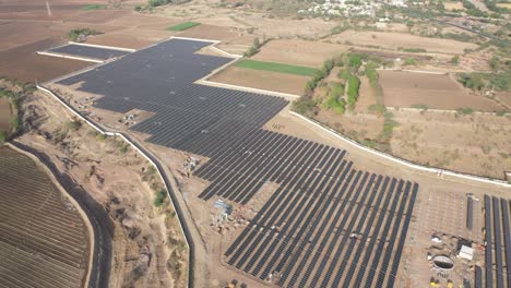 Aerial-wide-angle-shot-showing-a-large-solar-farm-in-a-large-field