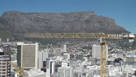 A-tower-crane-operates-at-city-high-rise-construction-site-with-Table-Mountain-as-backdrop