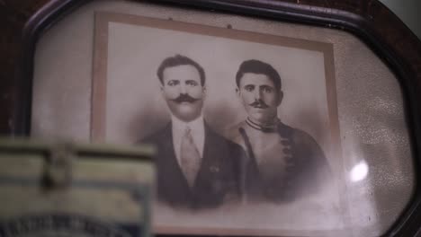 Pan-from-antique-pharmacy-tin-to-old-framed-photograph-of-two-men