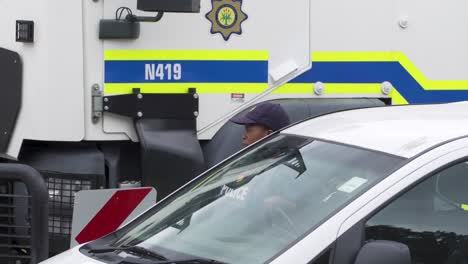 Polizistin-Mit-Markenfahrzeugen-Der-Südafrikanischen-Polizei-Am-Tatort,-Chat-Mit-Kollegin