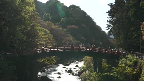 In-Filmischer-Zeitlupenaufnahme-überqueren-Einzelpersonen-Anmutig-Die-Shinkyo-Brücke-In-Der-Bezaubernden-Umgebung-Von-Nikko,-Japan