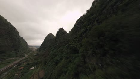 FPV-Drohne-Fliegt-In-Den-Nebligen-Bergen-über-Einem-Bergrücken-In-Der-Nähe-Der-üppigen-Grünen-Bäume-Und-Felsen