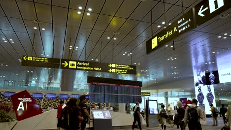 Reisende,-Die-An-Ankunfts--Und-Transferinformationsschaltern-Am-Flughafen-Changi-Vorbeigehen