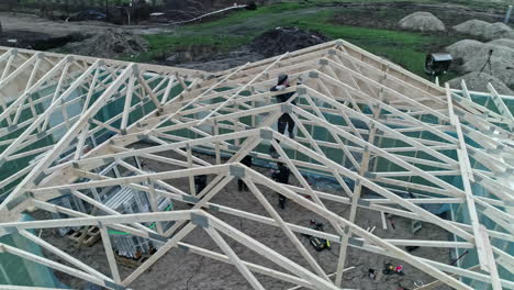 Circular-drone-footage-shows-the-roof-trusses-being-placed-on-a-prefabricated-house