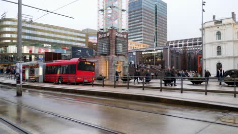 People,-buses-and-trams-come-and-go-at-Central-Station-in-Oslo,-Norway