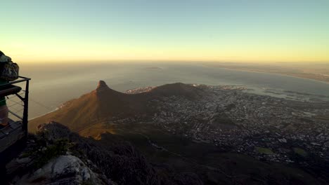 A-family-of-tourists-poses-for-a-photo-from-a-lookout-deck-on-top-of-Table-Mountain-while-the-camera-pans-across-to-reveal-the-beautiful-views-of-Cape-Town