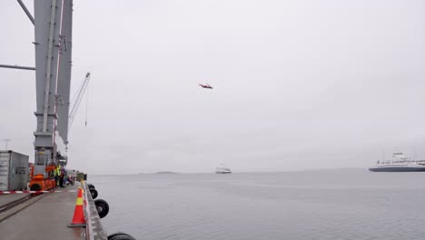 Adrenaline-junkie-does-a-dramatic-"Death-Dive"-from-a-platform-high-above-the-sea-on-a-cold-and-rainy-day-in-Moss,-Norway