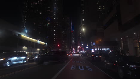 POV-shot-driving-on-the-7th-Avenue,-toward-the-HM-tower,-night-in-NYC