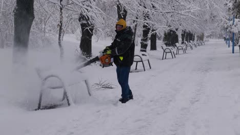 Hombre-Quitando-Nieve-En-El-Parque-Con-Soplador-De-Hojas.