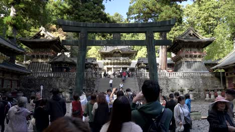 Slow-motion-of-tourists-in-front-of-the-Middle-Torii-gate-at-Nikko-Toshogu,-a-revered-cultural-heritage-site-in-Japan