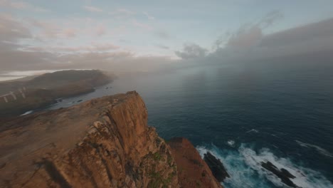 FPV-drone-cruising-on-the-edge-of-the-ridgeline-at-Ponta-do-Rosto-beach-during-sunrise