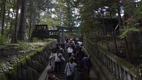 tourists-ascend-the-staircase-leading-to-Okusha-Hoto-in-Nikko,-Japan,-to-explore-the-structure-that-houses-the-remains-of-Tokugawa-Ieyasu