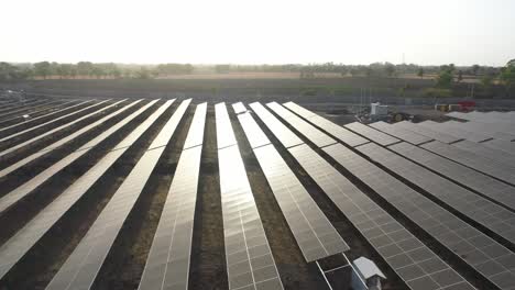 Aerial-drone-view-of-sunlight-falling-on-solar-panels-and-dawn-moving-towards-the-site