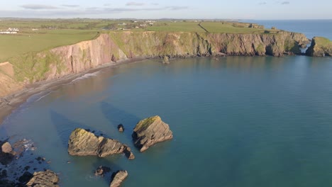 drone-golden-hour-hidden-bay-with-sea-stacks-at-Copper-Coast-waterford-Ireland