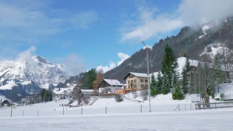 Ein-Herrlicher,-Schneebedeckter-Bergrücken-Ist-Auf-Einem-Panoramablick-Zu-Sehen,-Zusammen-Mit-Berghütten-Und-Häusern-Der-Einheimischen,-Engelberg,-Schweiz