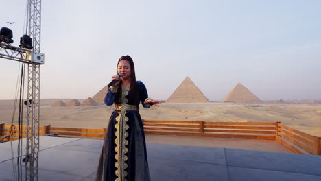 Un-Cantante-Actúa-En-Un-Escenario-Con-Vistas-A-Las-Pirámides,-Giza-En-Egipto-Primer-Plano