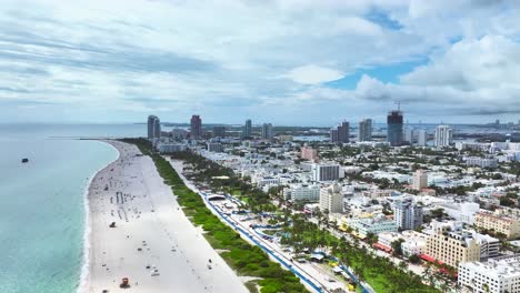 Maravillosas-Imágenes-Aéreas-De-Drones-De-Una-Playa-De-Arena-En-Miami,-EE.-UU.,-Toma-Frontal-Que-Captura-Un-Fascinante-Paisaje-Marino,-Con-Gente-Disfrutando-Incluso-Con-Nubes.