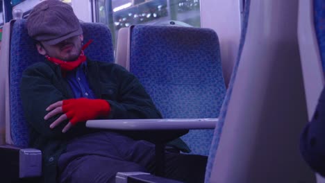 Character-dressed-in-1950s-clothing-pretends-to-be-asleep-on-train-journey
