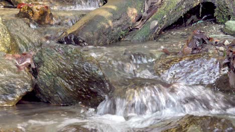 A-natural-stream-flows-over-a-rocky-surface